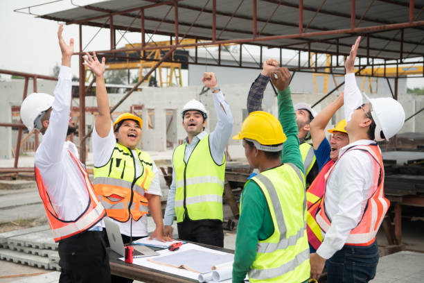 istock Construction engineers, architects, and foremen form a group. Participate in a meeting to plan new construction projects. Cheers to express happiness that the event was successfully accomplished. 1464484915