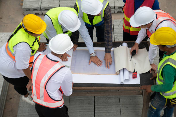 istock Construction engineers, architects, and foremen form a group. Participate in a meeting to plan new construction projects. 1464484919