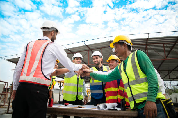 istock Construction engineers, architects, and foremen form a group. Participate in a meeting to plan new construction projects. Cheers to express happiness that the event was successfully accomplished. 1464484944