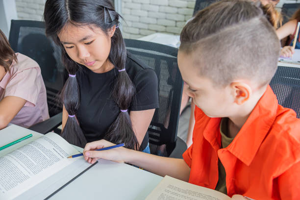istock male student teaching female student friend in classroom 1464485463