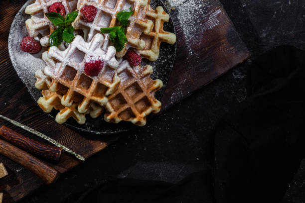 istock Belgian waffles with raspberries and mint on a dark plate 1464487576