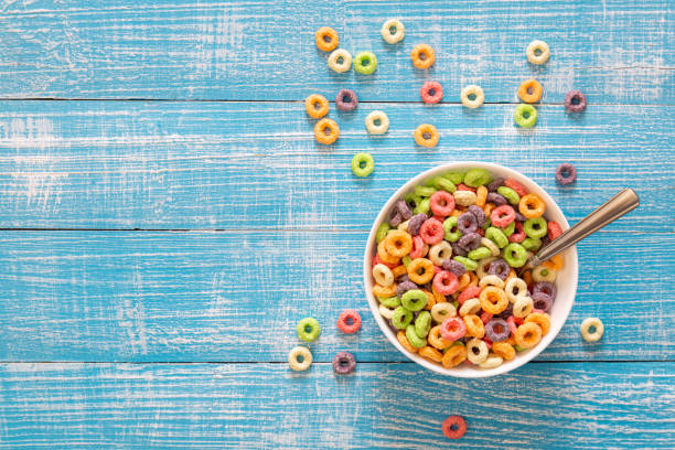 istock Colored breakfast cereals in a bowl on a blue wooden background, top view. 1464488096