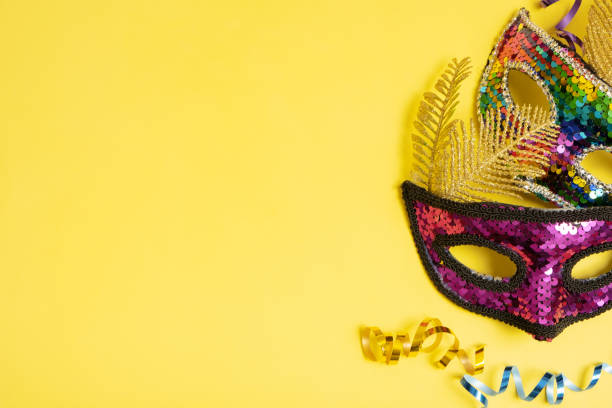 istock Festive face masks for masquerade or carnival celebration on colored background. Blank greeting card or invitation 1464490058