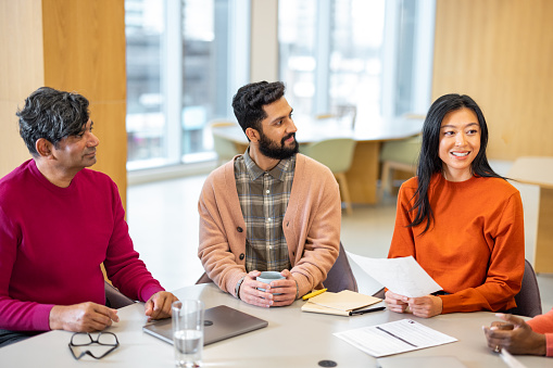Portrait of happy colleagues at conference table in office - stock photo