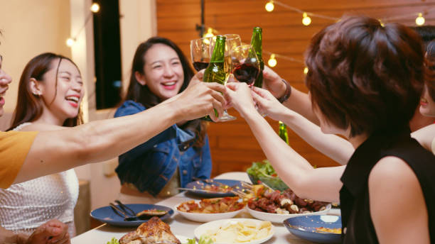 group of happy young asian people with friends celebrating clinking glasses during dinner party - wine dinner party drinking toast imagens e fotografias de stock