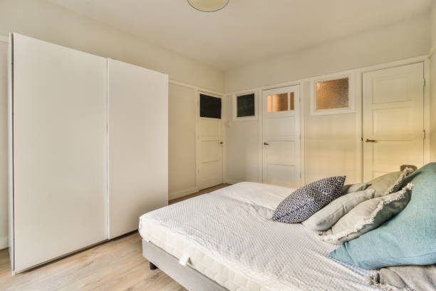 istock a bedroom with a bed and white closet doors 1464496619
