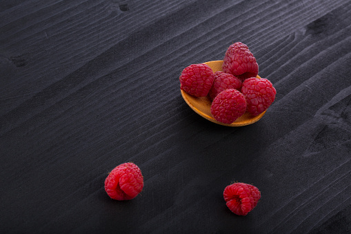 Fresh raspberry in a wooden plate