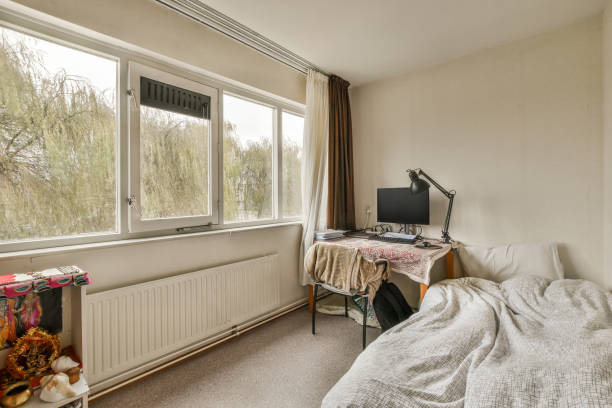 istock a bedroom with a bed a desk and a window 1464497071