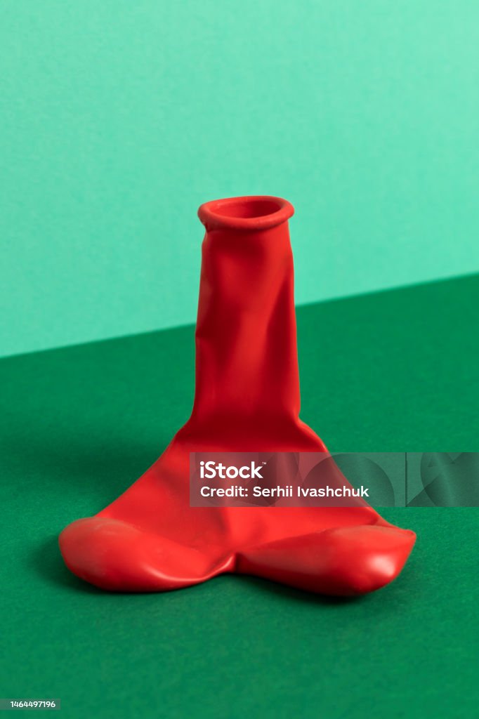 Deflated red balloon. Deflated red balloon. The shape of penis, male potency concept. Erectile Dysfunction Stock Photo