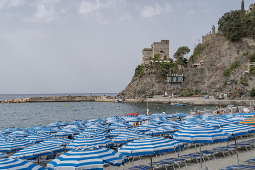 Colorful umbrellas on the beach of Cinque Terre on a sunny summer day