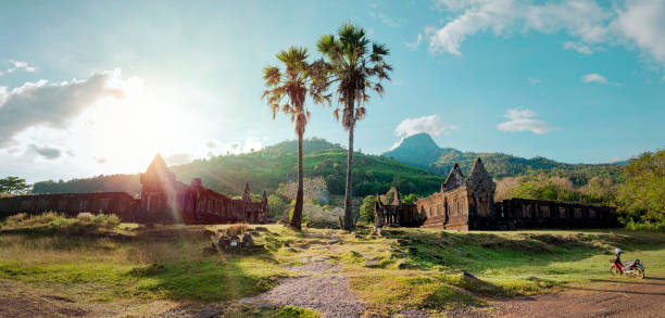 Beautiful sunset over mountains and palm trees. Wat Phu Khmer temple in Laos