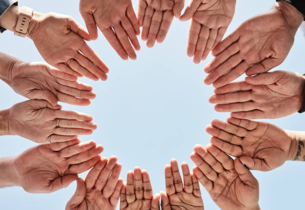 istock Hands, community and unity for team building, synergy or support in sync for teamwork and below blue sky background. Hand of people in partnership for goals, collaboration and trust in solidarity 1464504366