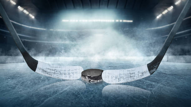 Ice hockey players on the grand ice arena - stadium Ice hockey players on the grand ice arena - stadium hockey puck stock pictures, royalty-free photos & images