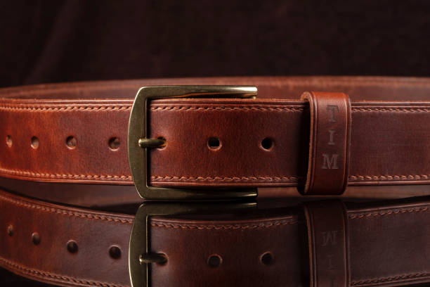 istock Leather brown belt on a dark background with reflection. 1464504734
