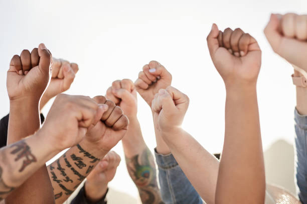 istock Protest, group fist hands and crowd support for justice, gender quality and community change outdoor. Revolution, freedom and human rights advocate hand gesture with students in solidarity together 1464507884