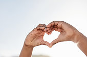 Heart, hand sign and love gesture of hands in the air to show support, peace and hope outdoor. Hearts emoji, kindness icon and trust symbol with a person showing solidarity, respect and care