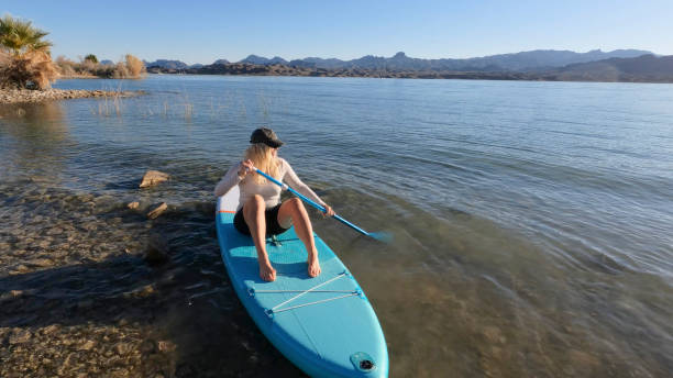 istock Mature woman relaxes on SUP, paddles 1464508004