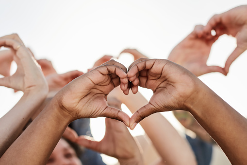 Group, heart hand sign and love gesture of hands in air to show support, peace and hope outdoor. Hearts emoji, gratitude and trust symbol with a people showing solidarity, diversity respect and care