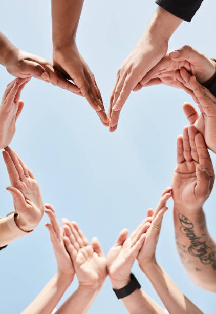 People, hands and unity for heart shape in support, collaboration or teamwork below a blue sky background. Hand of group touching forming love symbol in trust, community or team synergy outside People, hands and unity for heart shape in support, collaboration or teamwork below a blue sky background. Hand of group touching forming love symbol in trust, community or team synergy outside diversity hands forming heart stock pictures, royalty-free photos & images