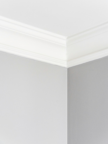 A basic cornice in the corner of a domestic room.