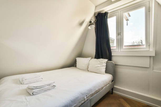 istock a small bedroom with a bed and two windows 1464513483
