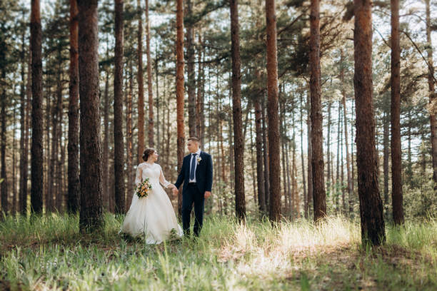 istock the bride and groom are walking in a pine forest 1464514626