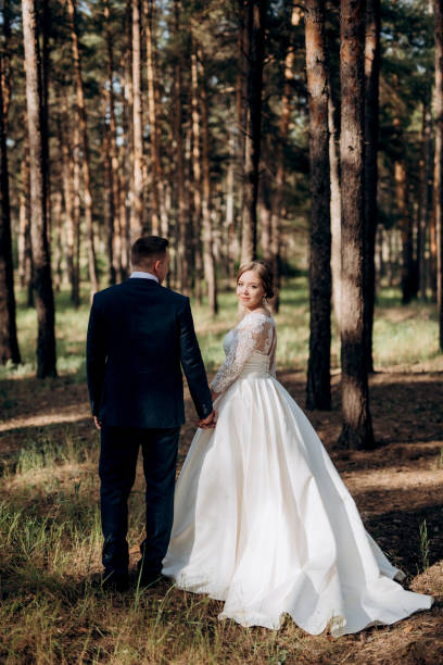 istock the bride and groom are walking in a pine forest 1464515048