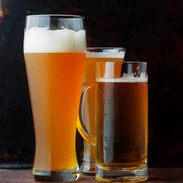 istock Three glasses of draft cold beer close-up dark background 1464521278