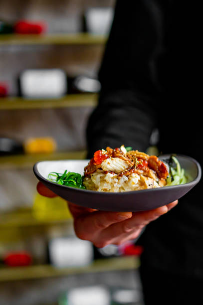 istock chef holding delicious poke bowl with fish, rice and vegetables 1464521437
