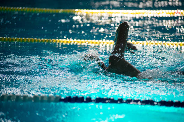 Asian child competing swimmer in the swimming pool