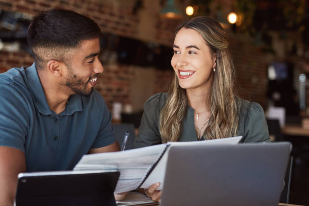 istock Happy business people, technology or reading documents in cafe, coffee shop or restaurant collaboration for startup budget. Talking, smile or teamwork and paper or strategy planning or remote working 1464536830