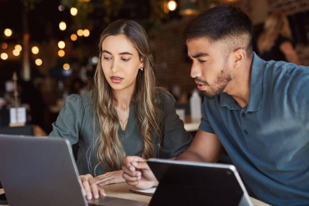 istock Business people, technology and thinking in cafe collaboration, strategy planning or startup innovation ideas. Man, woman and teamwork on laptop or tablet in remote working, coffee shop or restaurant 1464537158