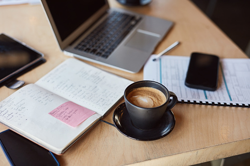 Coffee cup, technology or notebook paper in cafe or restaurant for startup budget, investment or loan insurance. Zoom, drink or cappuccino beverage and laptop, phone or tablet in remote work research