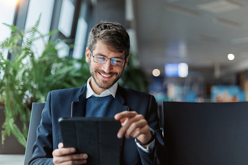 smiling man using a digital tablet during a trip. close-up.