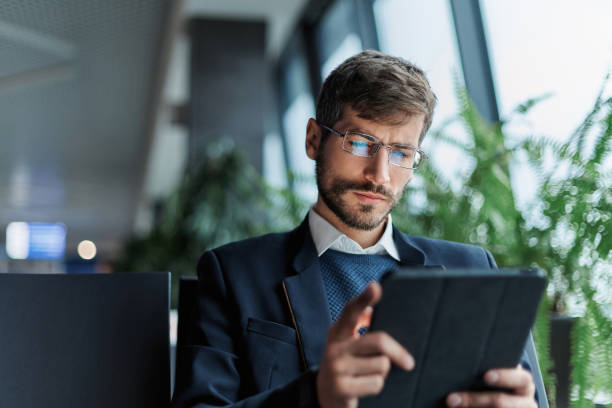 istock business man using a digital tablet during a business trip. 1464539751
