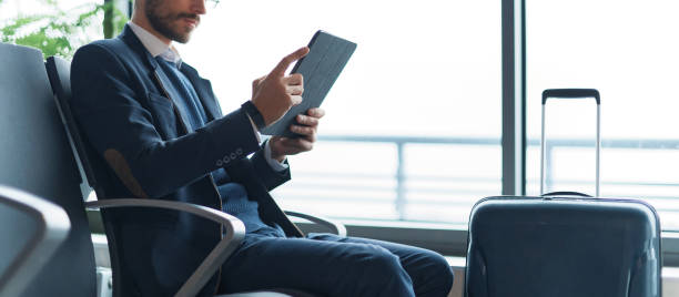 istock Man using digital tablet pc at an airport lounge, waiting room. 1464541266