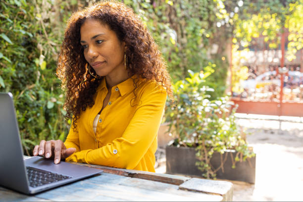istock Brazilian woman using laptop at garden 1464541775