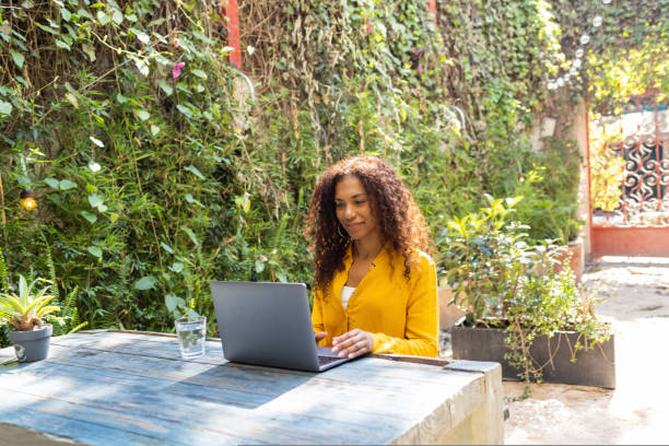 istock Brazilian woman using laptop at garden 1464543576