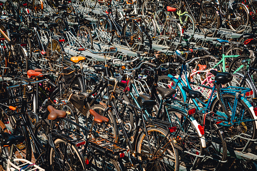 Bicycle handlebars of hundreds of bicycles wheels parked near of Amsterdam Train Station in Holland