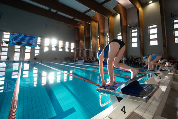 istock Swimmer girl start from the starting table in the pool 1464547682