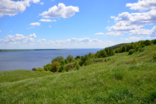 istock rolling hill with green grass, blue sky and white clouds and Volga river on horizon 1464548649