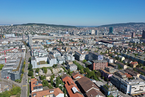 Zurich urban skyline.  The image shows the city district Albisrieden in foreground with several new residential buildings, captured during autumn season.