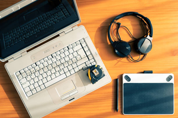 Wooden desk with a laptop computer with a headset. Graphic tablet and a flexometer.
