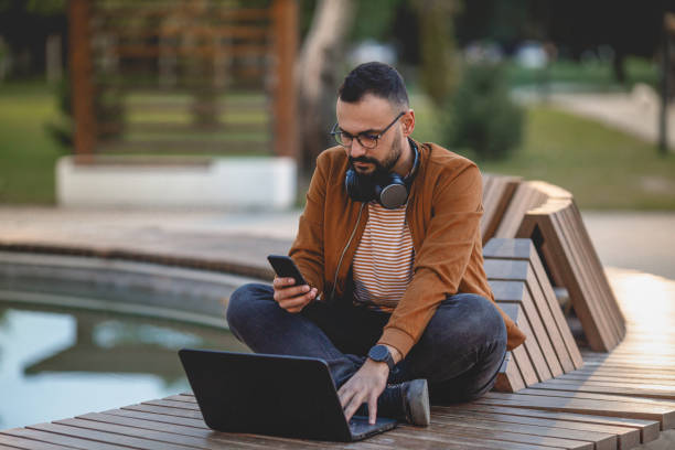 istock Man using phone on city street. 1464552434