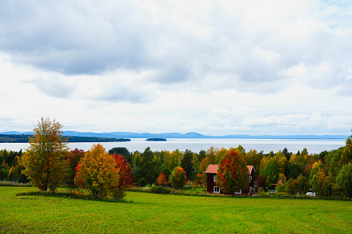 Wide meadows, autumn weather and blue lakes. Streets and houses near the big lake Siljan. Wide angle photography.