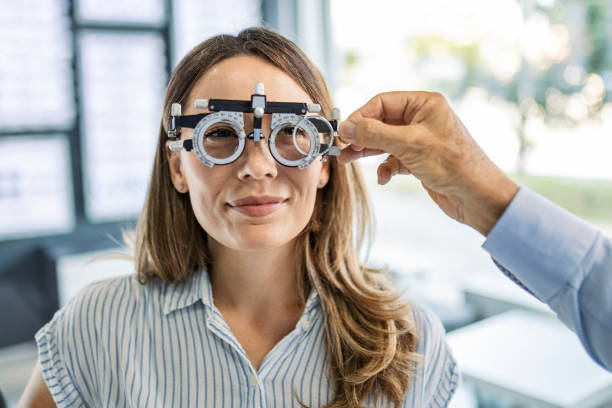 primer plano de una mujer joven que elige lentes para gafas que se ajustan a la óptica - human eye eyesight optometrist lens fotografías e imágenes de stock