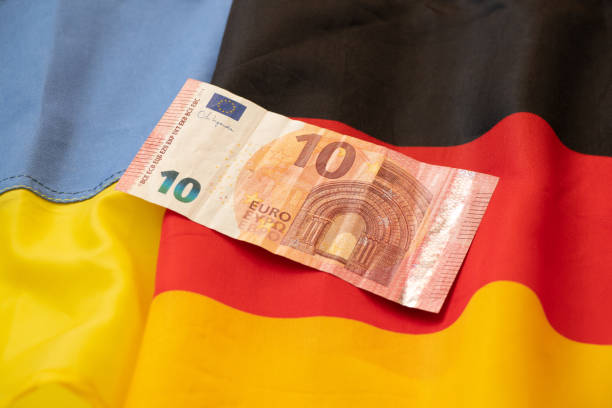 Two flags of Germany and Ukraine and ten euros as a background, unification and finance stock photo