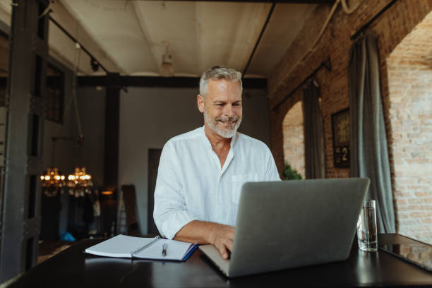 istock Smiling senior businessman working in luxurious New York style space 1464556671