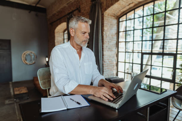 istock Serious senior businessman working in luxurious New York style space 1464556680