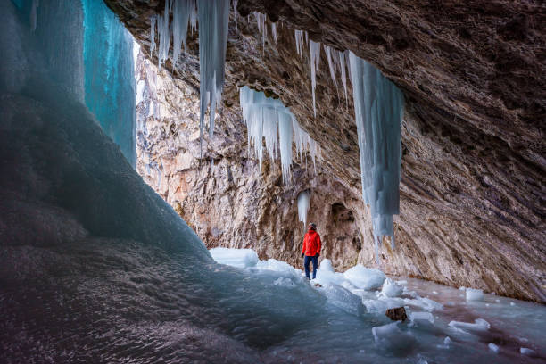 Hiker Exploring Frozen Ice Cave stock photo